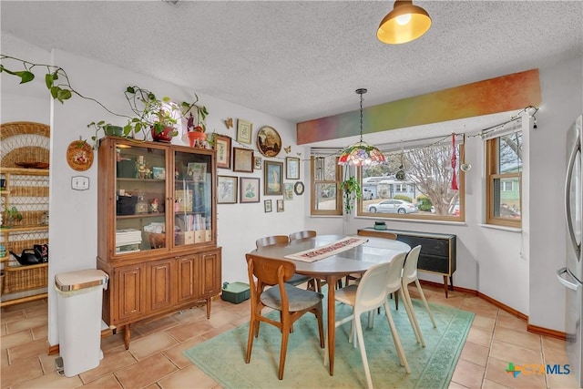 dining space with a textured ceiling and light tile patterned floors