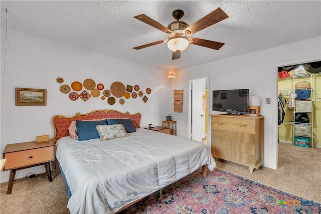 bedroom featuring ceiling fan, a textured ceiling, and carpet flooring