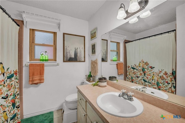 bathroom featuring a textured ceiling, toilet, tile patterned floors, and vanity