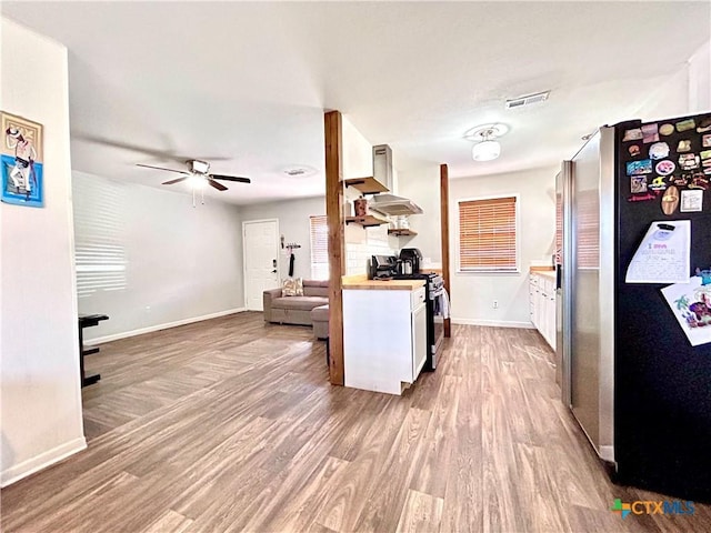 305 Carothers St, Copperas Cove, TX 76522 - kitchen featuring wall chimney exhaust hood, stainless steel appliances, wood finished floors, ceiling fan, and open floor plan