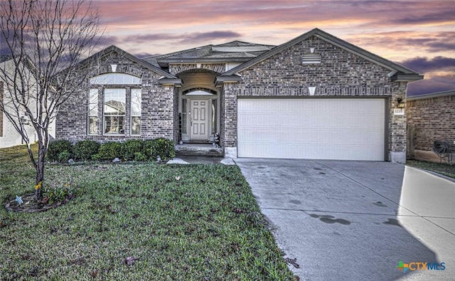 view of front of home featuring a garage and a lawn