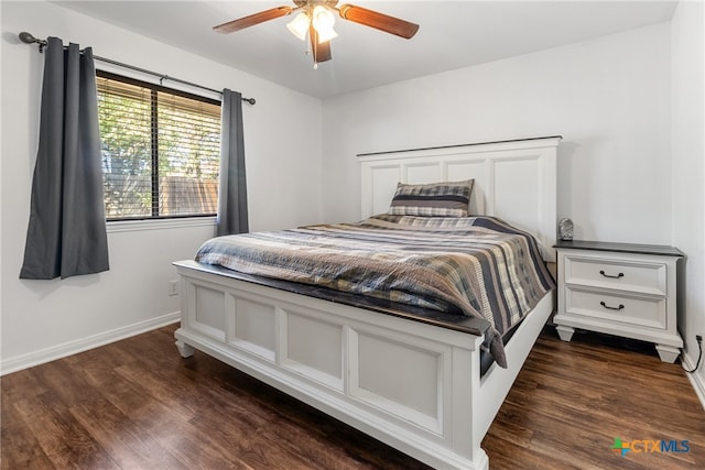 bedroom with dark hardwood / wood-style flooring and ceiling fan