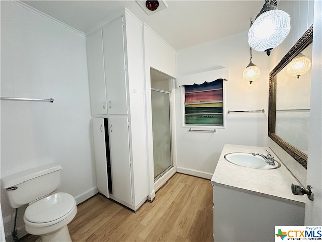 bathroom featuring walk in shower, toilet, wood-type flooring, and ornamental molding