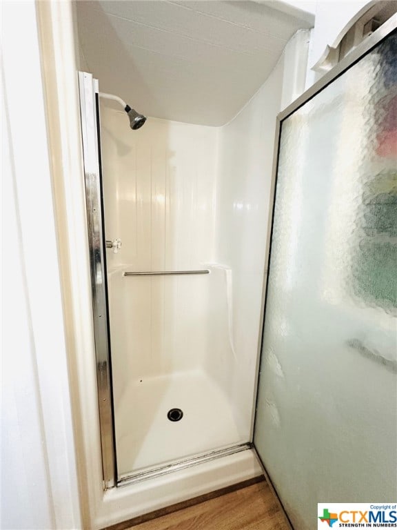 bathroom featuring walk in shower and hardwood / wood-style floors