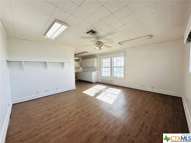 unfurnished living room with dark hardwood / wood-style flooring and ceiling fan