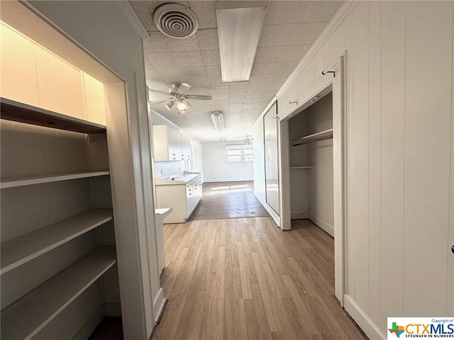 hall featuring crown molding and light hardwood / wood-style flooring