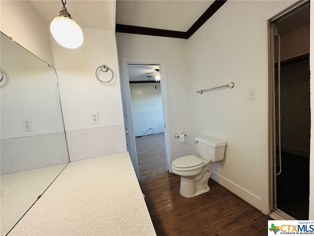 bathroom with toilet, hardwood / wood-style flooring, and ceiling fan