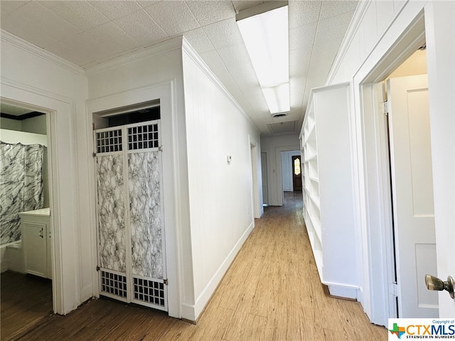 hall featuring light wood-type flooring and crown molding