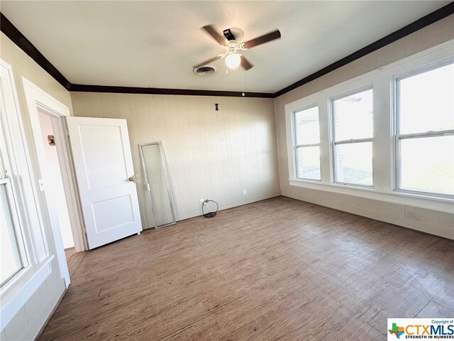 empty room with light hardwood / wood-style floors, ceiling fan, and ornamental molding