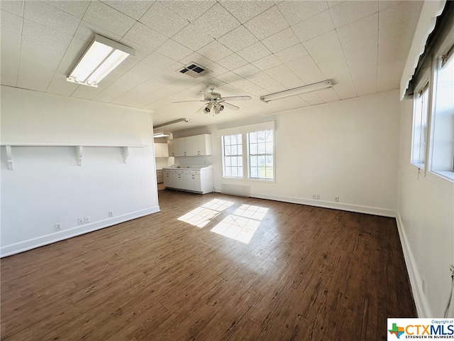 unfurnished living room with dark hardwood / wood-style floors and ceiling fan