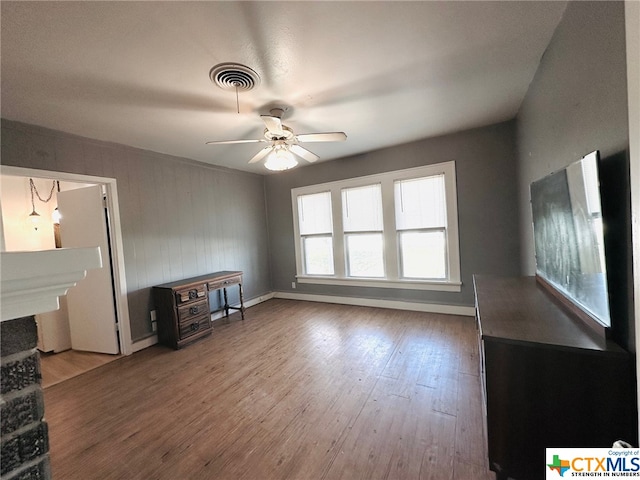 unfurnished living room featuring hardwood / wood-style flooring and ceiling fan