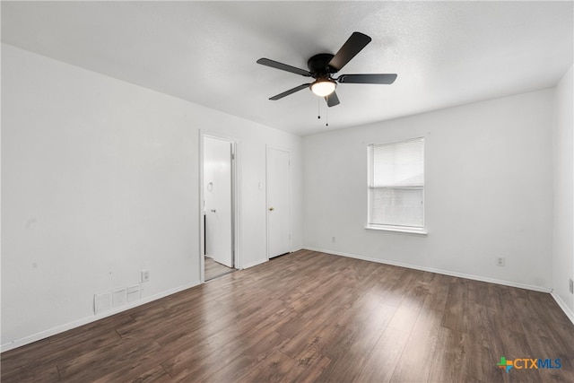 spare room featuring visible vents, ceiling fan, baseboards, and wood finished floors