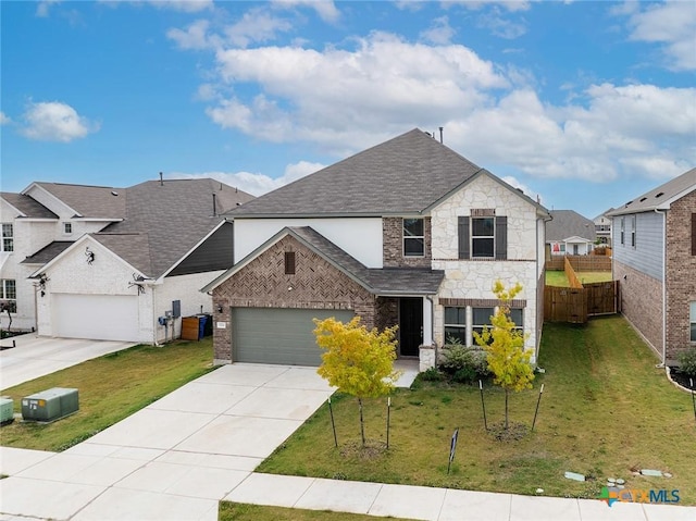 traditional-style house with a shingled roof, concrete driveway, a front yard, stone siding, and an attached garage