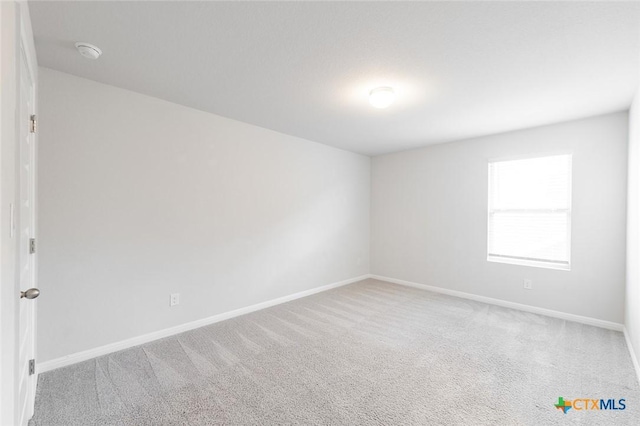 carpeted empty room with baseboards