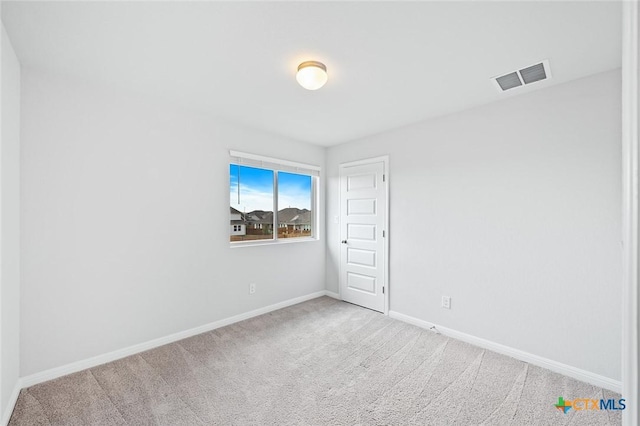 carpeted empty room featuring visible vents and baseboards