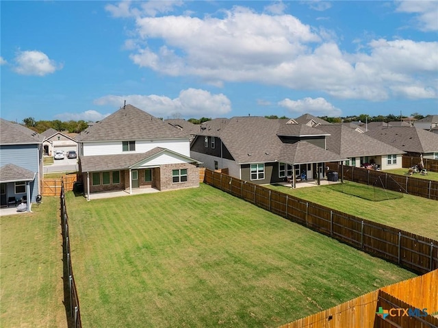 rear view of house with a patio, a yard, a fenced backyard, and a residential view