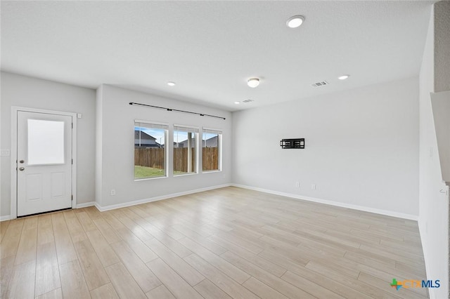 unfurnished living room with visible vents, recessed lighting, light wood-type flooring, and baseboards