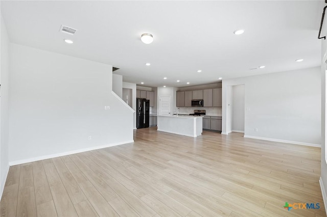 unfurnished living room featuring visible vents, recessed lighting, baseboards, and light wood-style floors