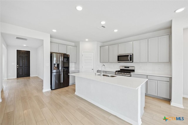 kitchen featuring a sink, visible vents, light wood-type flooring, and appliances with stainless steel finishes