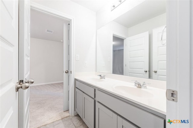 bathroom featuring double vanity, baseboards, visible vents, and a sink