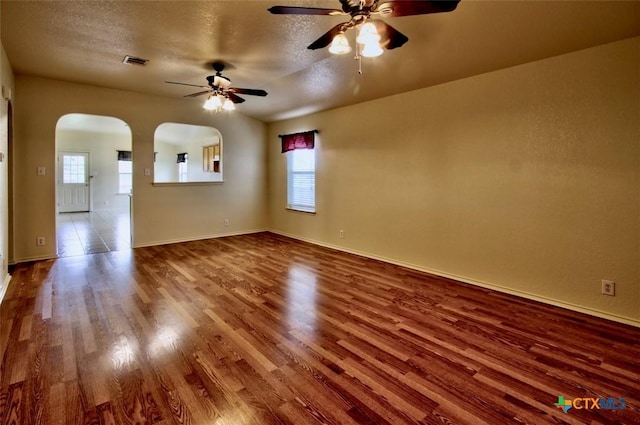 219 Starling Crk, New Braunfels, TX 78130 - spare room with wood finished floors, a ceiling fan, arched walkways, a textured ceiling, and baseboards