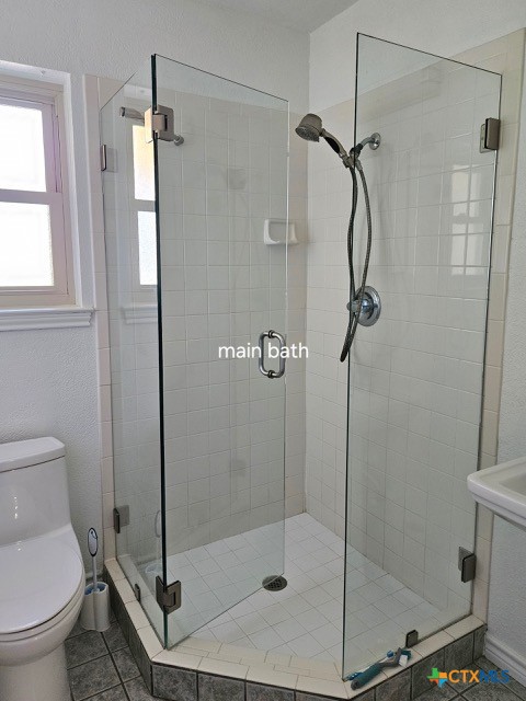 bathroom featuring tile patterned floors, a stall shower, and toilet
