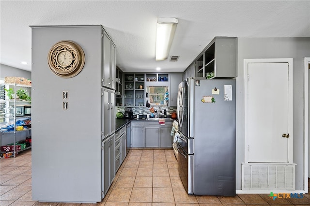 kitchen with gray cabinetry, freestanding refrigerator, open shelves, and visible vents