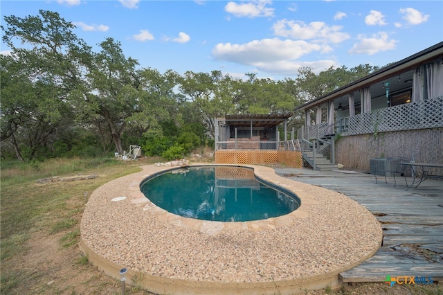 pool featuring central AC, a deck, and stairway
