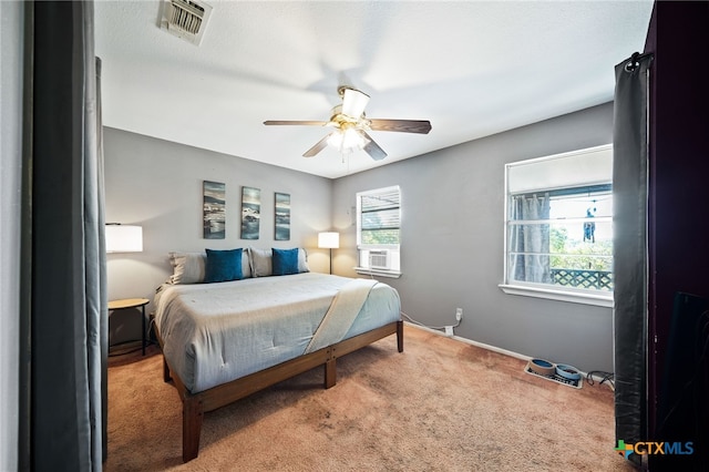 carpeted bedroom featuring visible vents, baseboards, cooling unit, and multiple windows