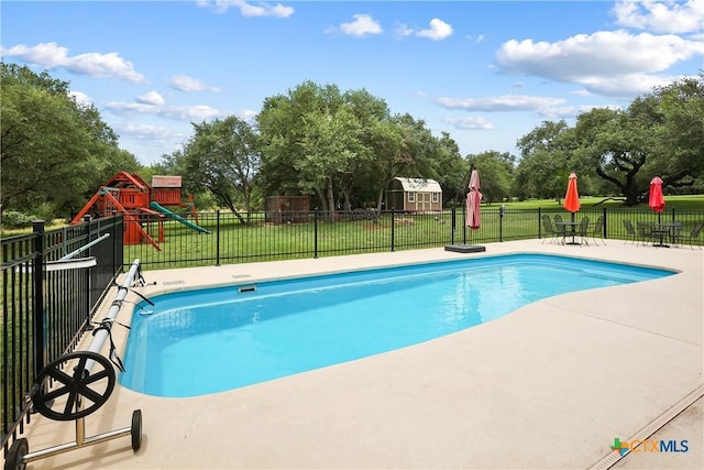 335 Mill Run, New Braunfels, TX 78132 - view of swimming pool featuring a playground, a patio, and view of wooded area