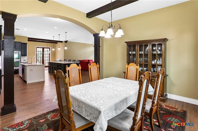 335 Mill Run, New Braunfels, TX 78132 - dining room with arched walkways, decorative columns, dark wood-style floors, recessed lighting, and a chandelier