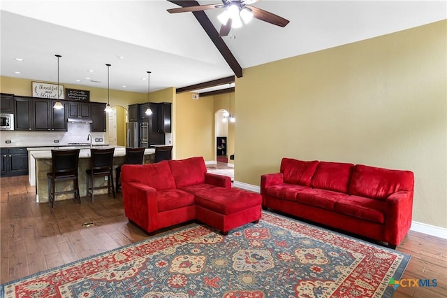 335 Mill Run, New Braunfels, TX 78132 - living area featuring arched walkways, dark wood finished floors, ceiling fan, recessed lighting, and beam ceiling