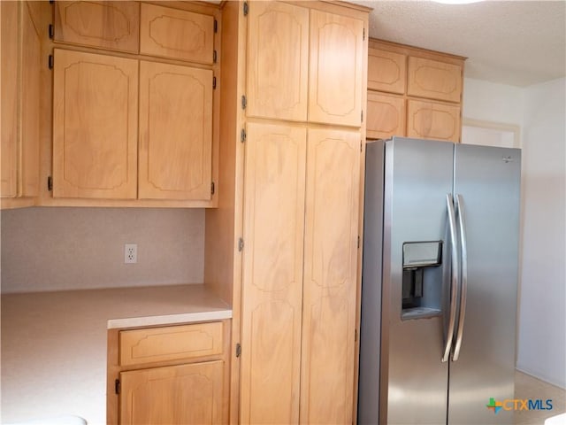 kitchen featuring stainless steel fridge and light brown cabinets