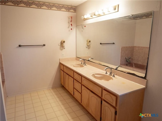 bathroom with a bathtub, vanity, and tile patterned flooring