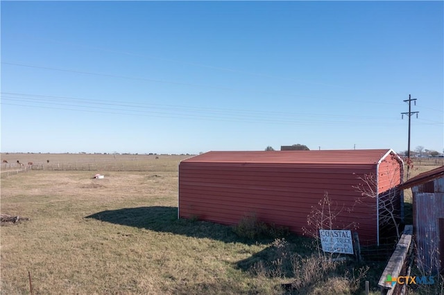 view of yard with a rural view and an outbuilding