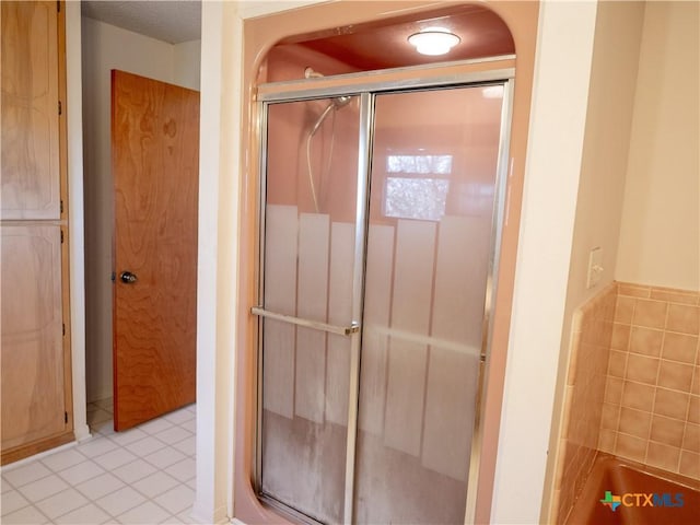 bathroom featuring a shower with shower door and tile patterned flooring