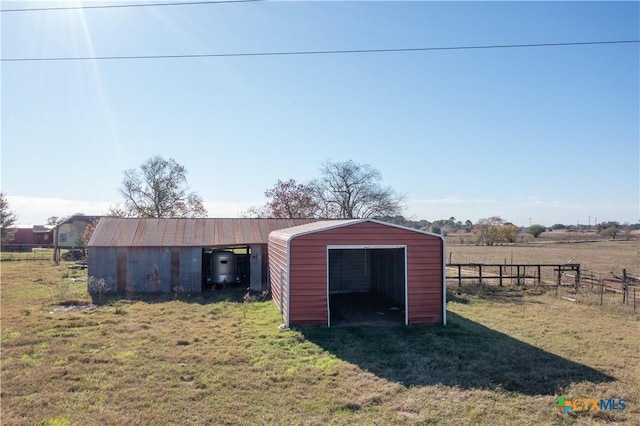 view of outdoor structure featuring a rural view and a lawn