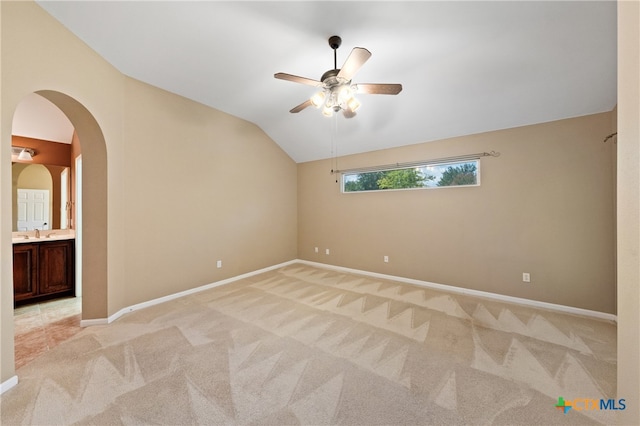 spare room with sink, ceiling fan, light carpet, and lofted ceiling