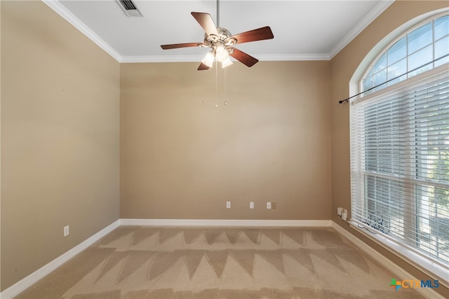 carpeted spare room with ceiling fan and crown molding