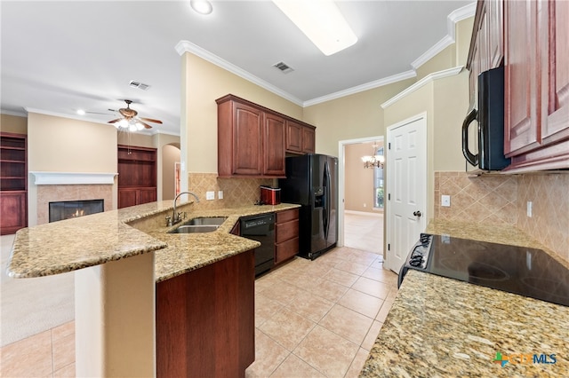 kitchen featuring black appliances, kitchen peninsula, sink, and a breakfast bar