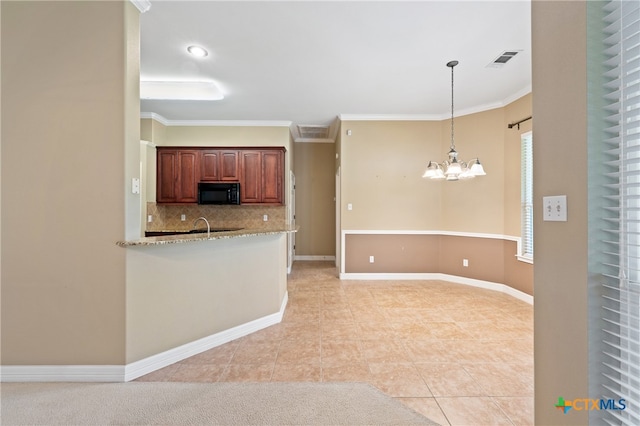 kitchen with light stone counters, crown molding, a notable chandelier, pendant lighting, and decorative backsplash