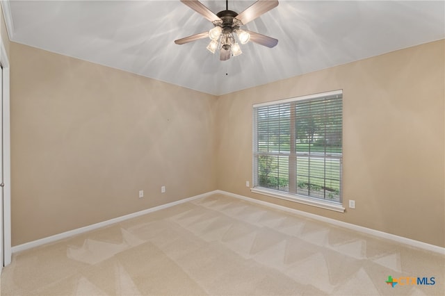 carpeted spare room featuring ceiling fan