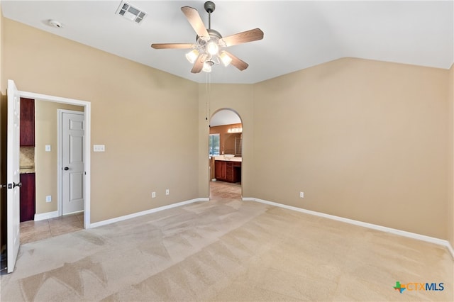 unfurnished room with light carpet, ceiling fan, and vaulted ceiling