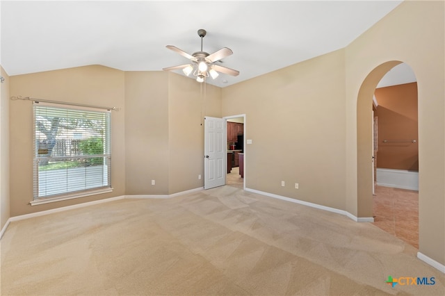 unfurnished room with light colored carpet, ceiling fan, and vaulted ceiling