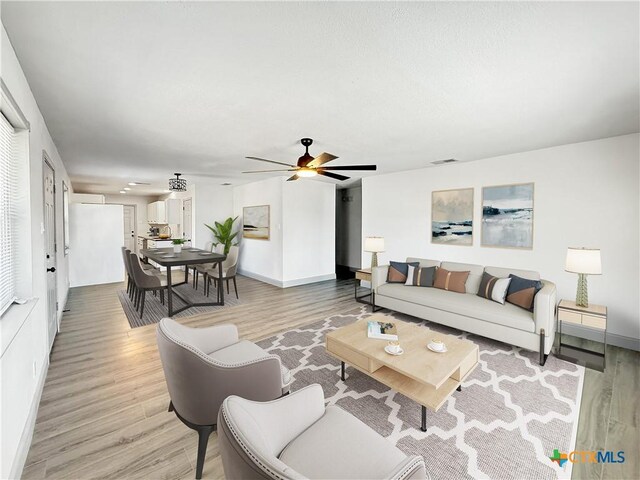 empty room with wood-type flooring, ceiling fan, and a textured ceiling