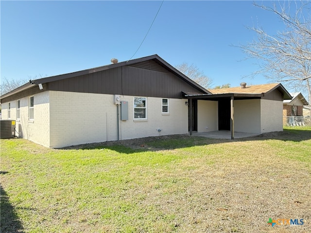 back of property featuring cooling unit and a yard