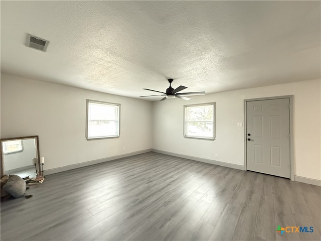 empty room featuring ceiling fan, light hardwood / wood-style floors, and a textured ceiling