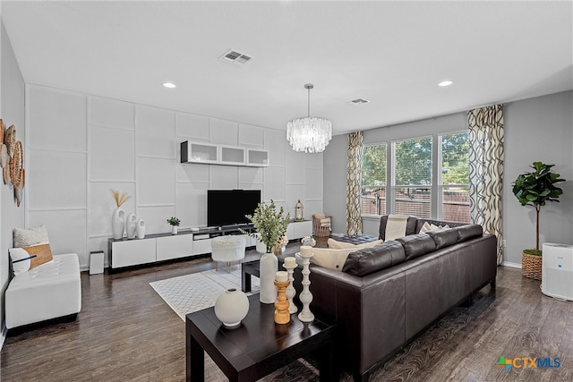 living room with dark wood-type flooring and an inviting chandelier