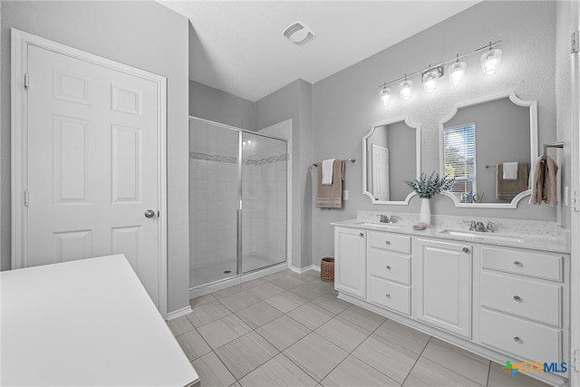 bathroom with vanity, tile patterned floors, and a shower with door