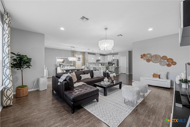 living room featuring dark wood-type flooring and a chandelier